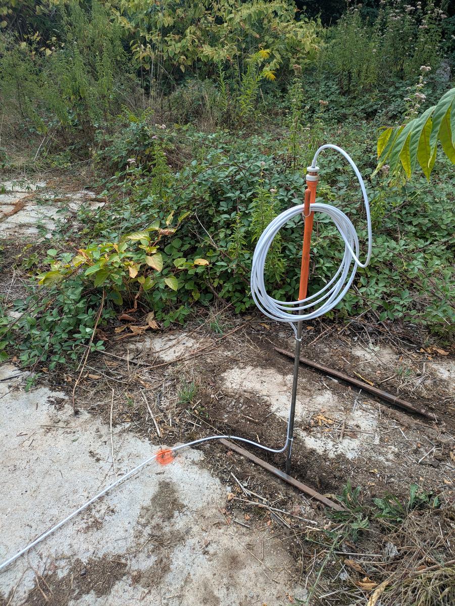 Earth spike driven into the ground beside the rails, cable coiled above it